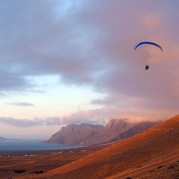 Vista panorámica de Caleta de Famara con el mar y las montañas de fondo, Lanzarote